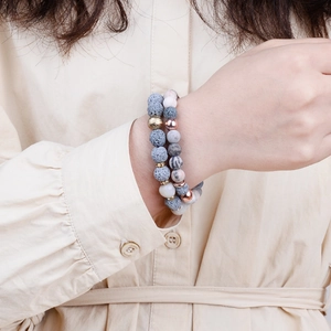 Lava stone bead bracelet set with grey volcanic rock and marble beads on a model's wrist