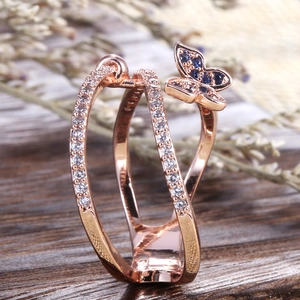 Macro side view of rose gold butterfly ring with blue and white zircon stones