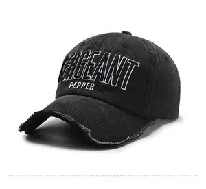 Close-up of vintage washed black denim cap with white Sergeant Pepper embroidery