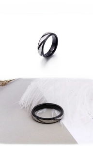 Détail de bague en acier titane noir avec texture brossée argentée et rayures obliques