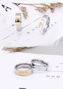 Detail of silver and gold stainless steel couple rings with Forever engraving