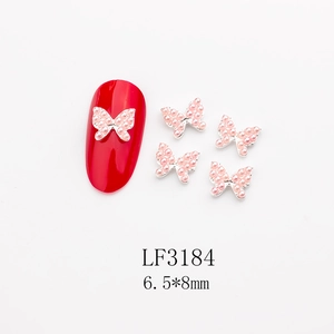 Macro shot of silver butterfly nail charms with pink pearls and 6.5x8mm size details