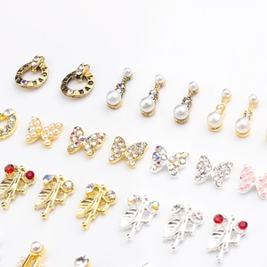 Detail of alloy nail charms with pearls, rhinestones, butterfly and heart shapes