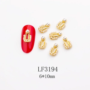 Detail of horseshoe nail art charm with pearls on red manicure showing 6x10mm size