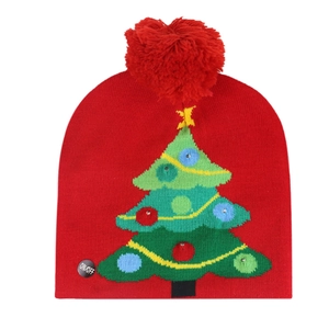 Detail view of the LED ON/OFF switch on a festive red knit Christmas tree beanie hat