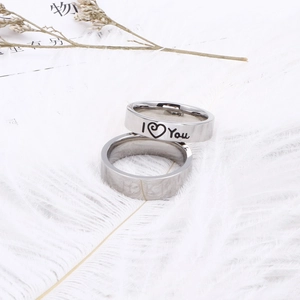 Minimalist stainless steel couple rings with I Love You engraving on soft feather background