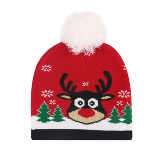Close-up of red Christmas knit hat featuring a reindeer pattern and white pom-pom top