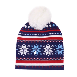 Close-up of winter knit hat featuring blue and red snowflake patterns and white pom-pom