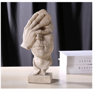 Detailed close-up of a resin Nordic sculpture featuring a hand covering eyes on a wooden desk