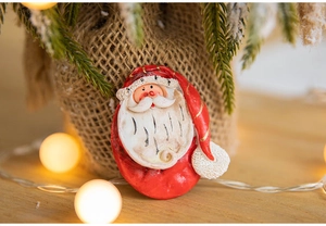 Macro view of Santa Claus figurine with festive pine branches and warm glowing lights