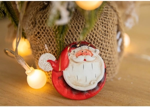 Close-up of Santa Claus resin magnet decoration on burlap with warm festive lighting