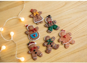Detailed view of six 3D gingerbread man fridge magnets on a warm wooden surface