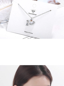 Macro shot of silver aurora crystal necklace with a teapot pendant on a white display card