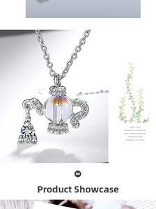 Macro detail of teapot-shaped pendant with iridescent orb and pear-cut gemstone