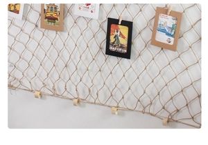 Detail of Mediterranean fishing net wall decor with clips for photo display