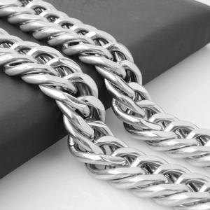 Polished silver double-buckle Cuban link necklace displayed on a black matte surface
