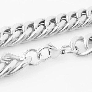 Macro shot of polished silver Cuban chain link necklace with a lobster clasp closure