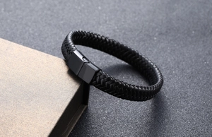Close-up of black braided leather bracelet with matte metal magnetic clasp on a gift box