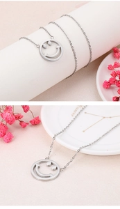 Vue détaillée d'un collier pendentif smiley en argent sur un support décoratif