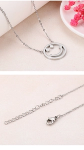 Gros plan du pendentif smiley argenté avec fermoir mousqueton et détails de la chaîne