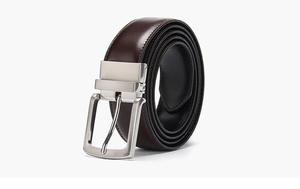 Macro shot of dark brown leather belt with rotatable silver metal buckle on white background