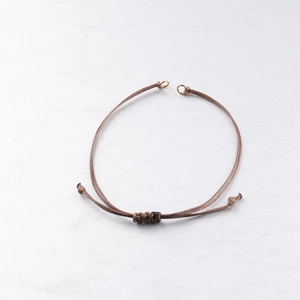 Detail of adjustable 0.8mm brown waxed cord bracelet with gold metal rings