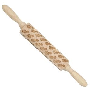 Macro view of wooden rolling pin showing detailed pineapple pattern embossing on texture