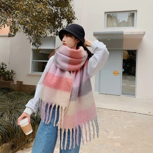 Detail of pink and purple rainbow plaid scarf featuring long chunky fringes on the edge