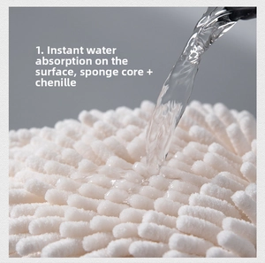 Close-up detail of white chenille hand towel ball absorbing water, sponge core interior view.