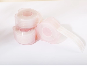 Detail of disposable invisible lace eyelid tape in pink heart-shaped containers