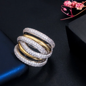 Macro shot of two-tone crisscross ring with micro-pave crystals and gold finish