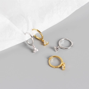 Detail of S925 sterling silver hoop earrings with three small dangling sparkling diamonds