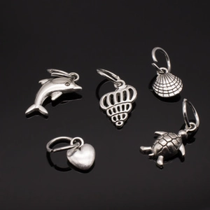 Detailed set of silver dolphin, shell, conch, heart and turtle jewelry pendants