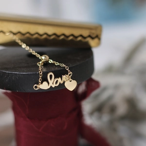 Detailed macro shot of adjustable 14K gold plated chain ring with love letter and heart charm
