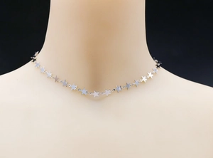 Detailed view of silver star choker necklace shown on a model neck display