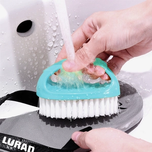 Egg-shaped laundry brush with green handle and nylon bristles cleaning a flip-flop
