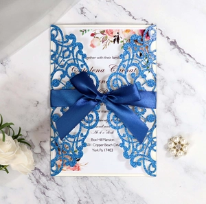 Navy blue laser-cut wedding invitation with glitter finish and satin ribbon bow decoration