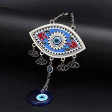 Detailed view of silver Evil Eye charm with blue enamel inlays and hanging glass beads