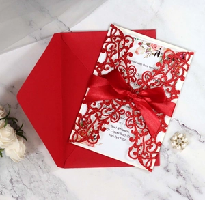 Detail of dark green laser-cut wedding invitation with glitter finish and satin ribbon