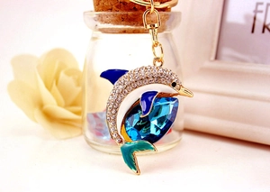 Detailed close-up of a golden dolphin keychain with blue crystal and sparkly rhinestones
