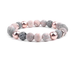 Macro shot of pink marble beads, grey lava stones, and rose gold metal beads in yoga bracelet