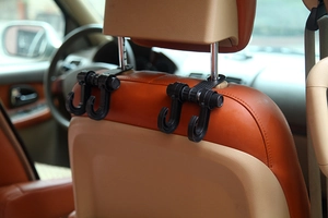 Dual car seat headrest hooks in black plastic installed on metal rod for bags