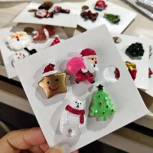 Detail of acrylic Christmas brooches featuring Santa, polar bear, and tree with glitter