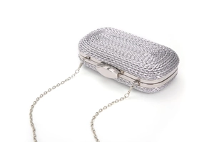 Detail of silver woven clutch bag with metallic frame and elegant chain strap for evening