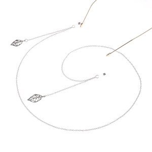 Detailed macro view of silver glasses chain with leaf pendants and non-slip rubber loops