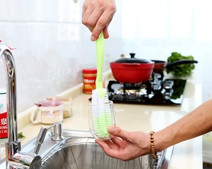Aktion einer Langgriff-Spülbürste beim Reinigen eines Glasbechers in einer hellen Küche