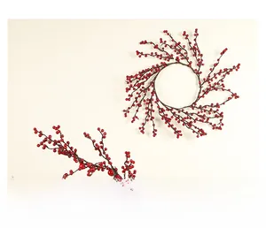 Vue détaillée de la couronne de baies rouges artificielles et branches de Noël
