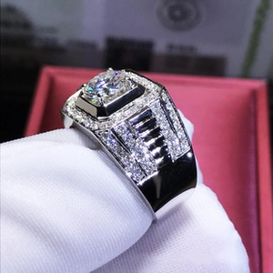 Detailed shot of men's silver honeycomb ring with moissanite center stone and side diamonds