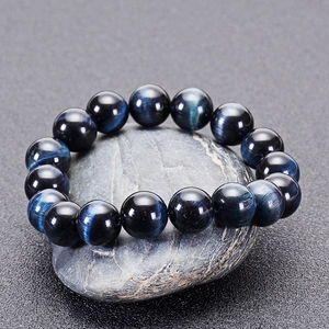 Macro detail of natural blue tiger eye stone beads with polished cat-eye light effect