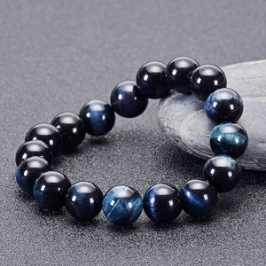 Detailed close-up of dark blue tiger eye stone beads showing natural silk luster and cat-eye effect
